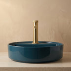Robinet lavabo Aura or brossé au-dessus d'une vasque, vue rapprochée
