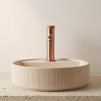 Robinet lavabo Aura or rose brossé installé sur une vasque à poser