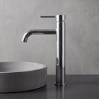 Robinet lavabo Dora Chrome Poli modèle haut vu de profil à côté d'une vasque à poser
