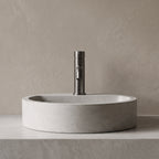 Robinet lavabo Dora Gun Metal modèle standard vu de face derrière une vasque à poser