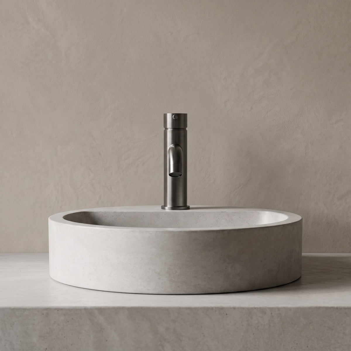 Robinet lavabo Dora Gun Metal modèle standard vu de face derrière une vasque à poser