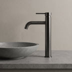 Robinet lavabo Dora Gun Metal modèle haut vu de profil à côté d'une vasque à poser