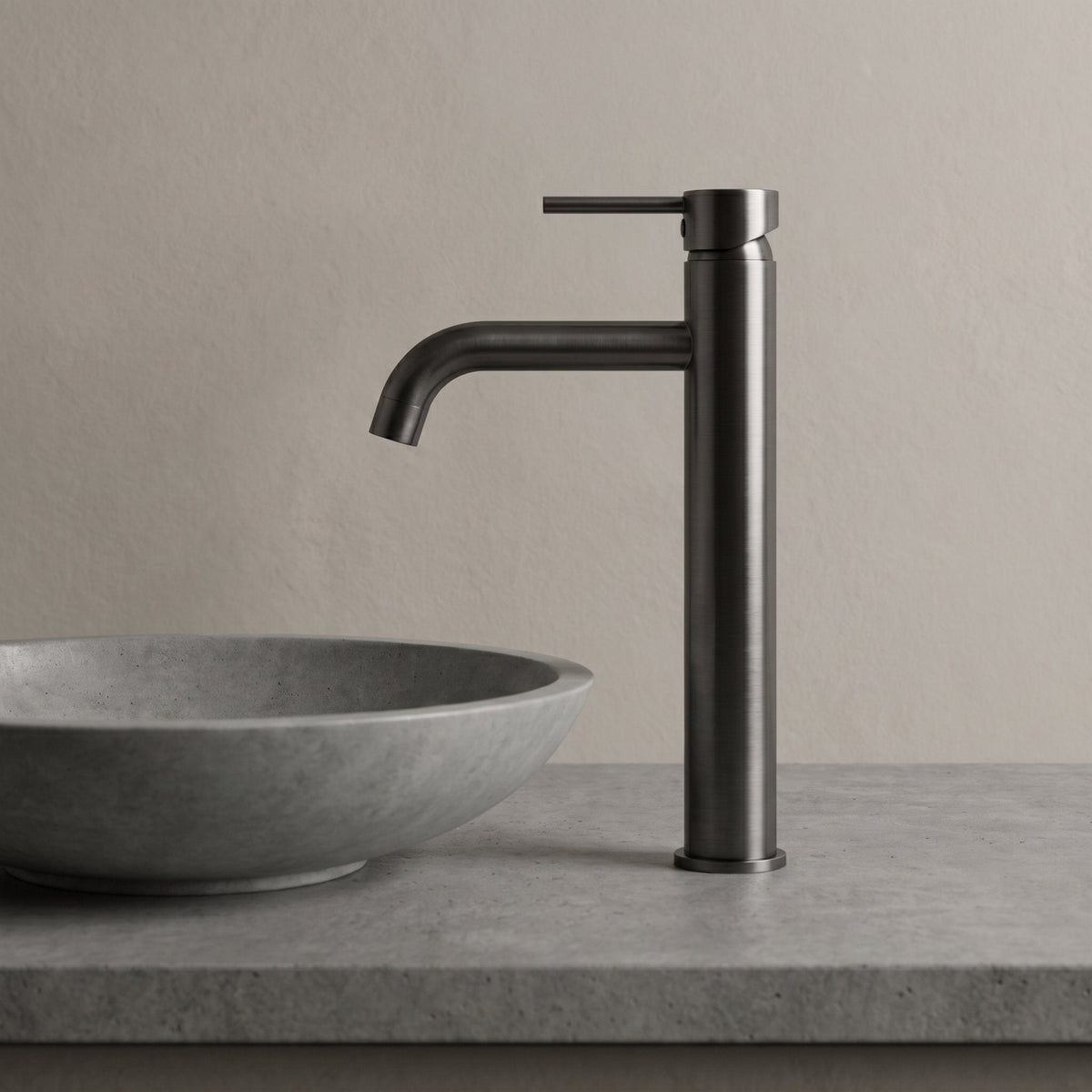 Robinet lavabo Dora Gun Metal modèle haut vu de profil à côté d'une vasque à poser