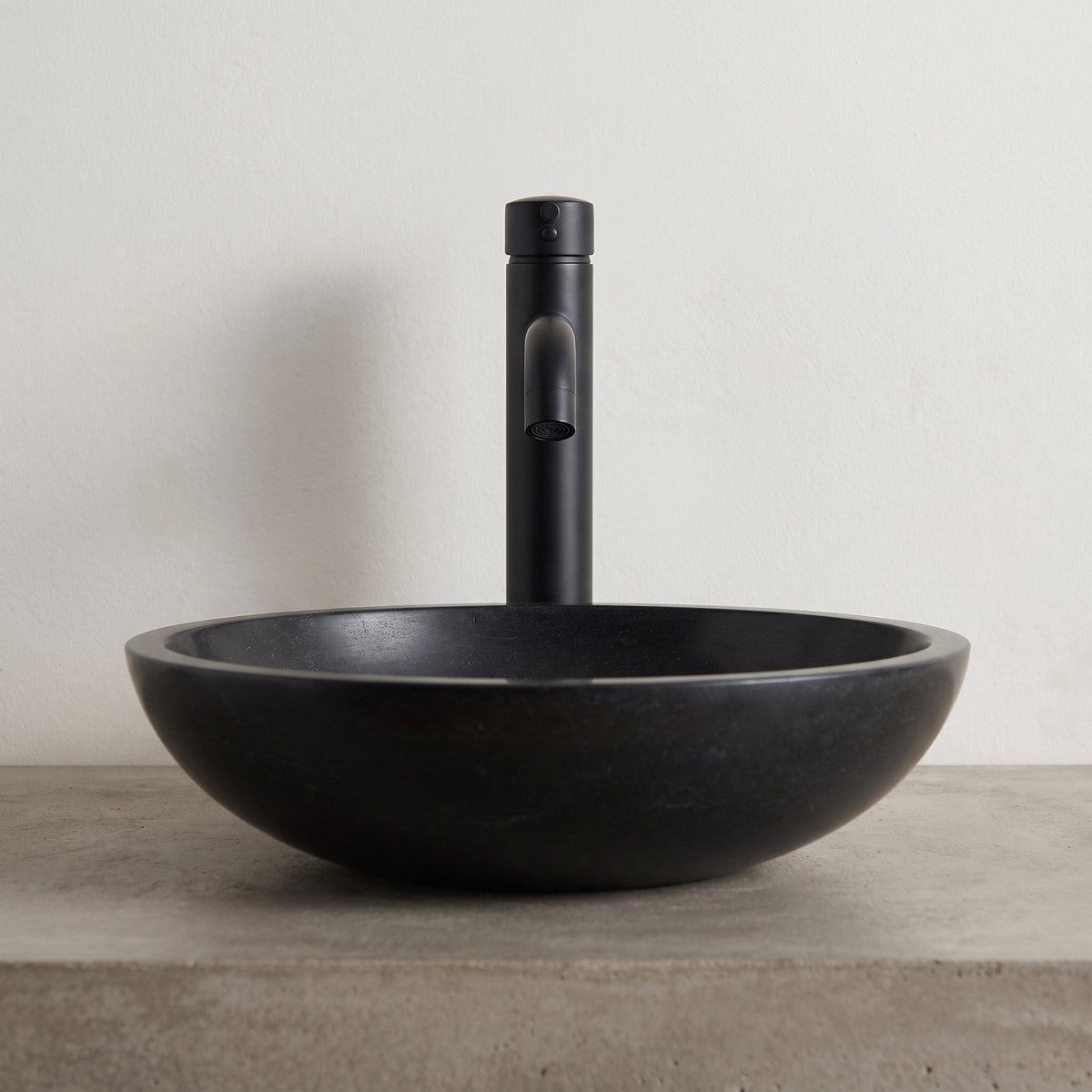 Robinet lavabo Dora Noir Mat modèle haut vu de face derrière une vasque à poser