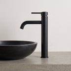 Robinet lavabo Dora Noir Mat modèle haut vu de profil à côté d'une vasque à poser