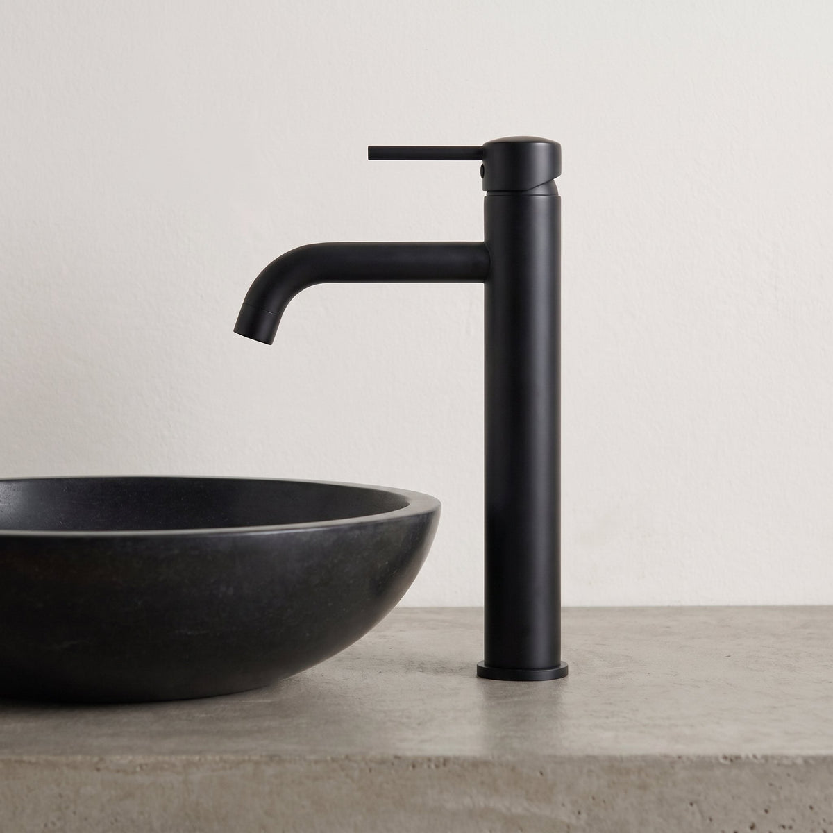 Robinet lavabo Dora Noir Mat modèle haut vu de profil à côté d'une vasque à poser