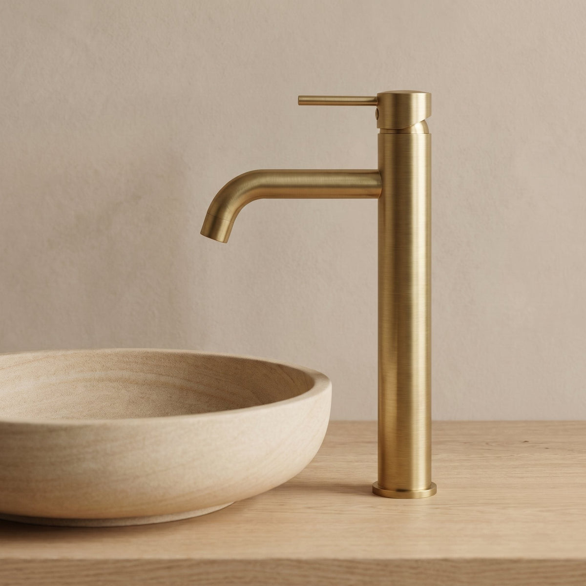 Robinet lavabo Dora Or Brossé modèle haut vu de profil sur une vasque en grès