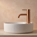 Robinet lavabo Dora Or Rose Brossé modèle standard vu de profil près d'une vasque à poser