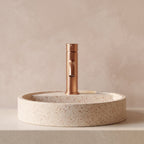 Robinet lavabo Dora Or Rose Poli modèle standard vu de face derrière une vasque à poser