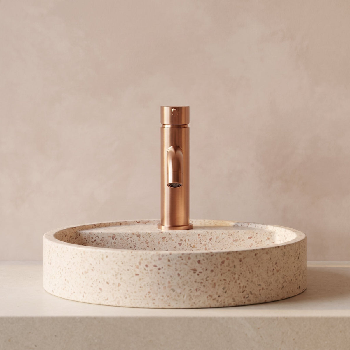 Robinet lavabo Dora Or Rose Poli modèle standard vu de face derrière une vasque à poser