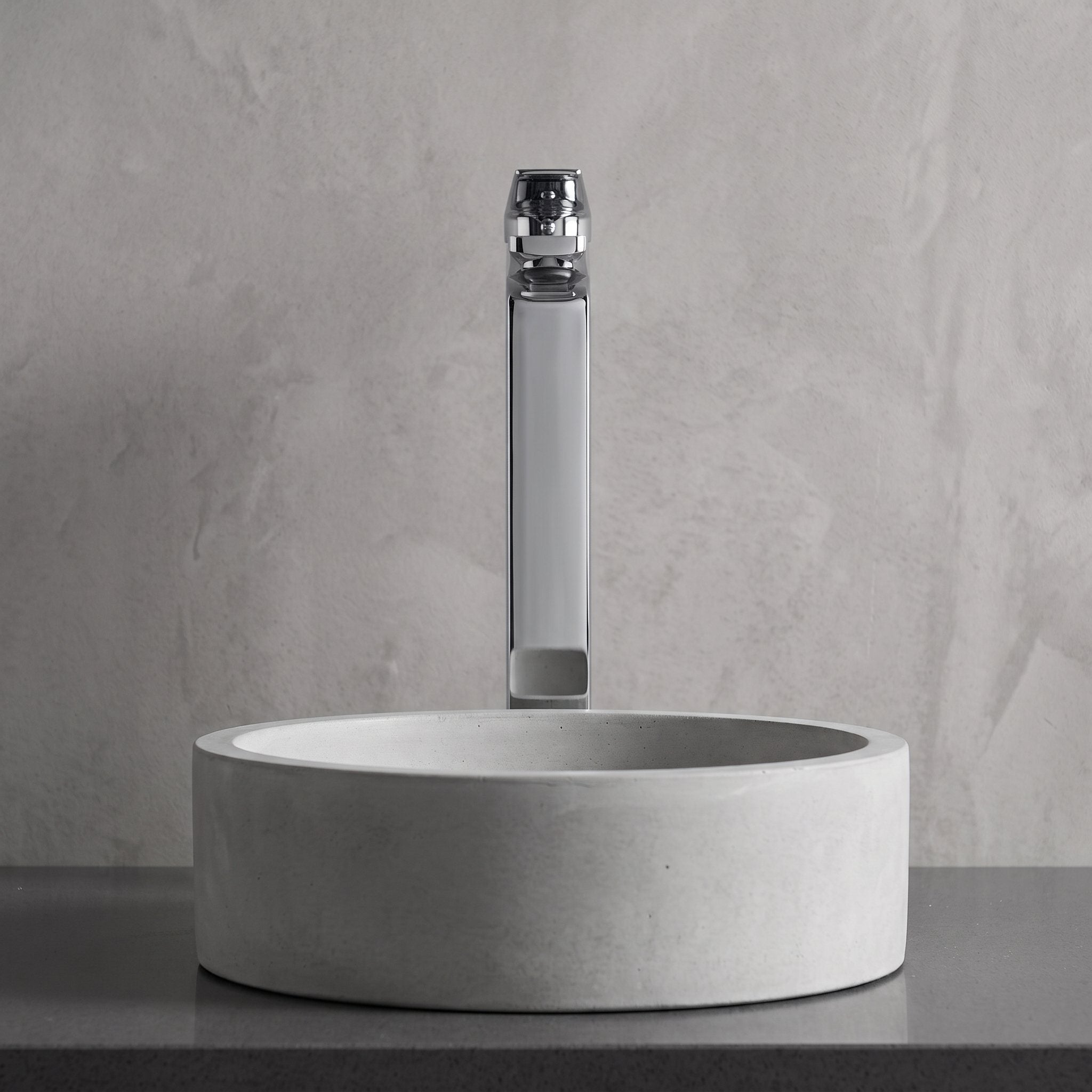 Robinet lavabo Metra Chrome Poli modèle haut vu de face derrière une vasque à poser