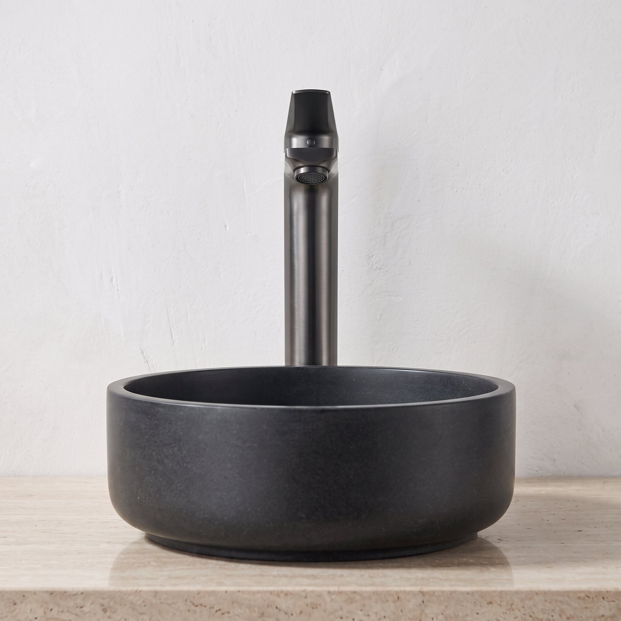 Robinet lavabo Metra Gun Metal modèle haut vu de face derrière une vasque à poser