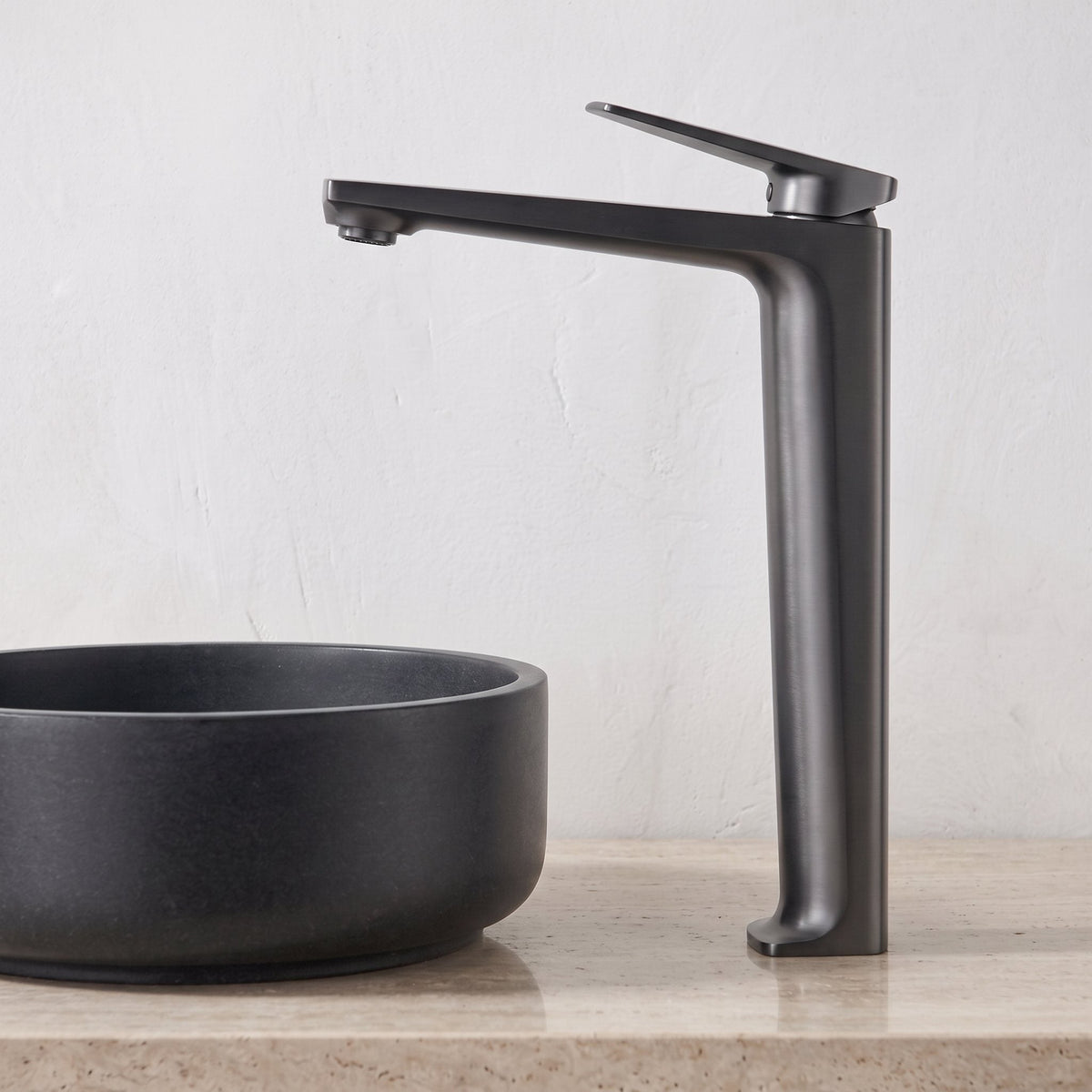Robinet lavabo Metra Gun Metal modèle haut vu de profil derrière une vasque à poser