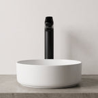 Robinet lavabo Metra Noir Mat modèle haut vu de face derrière une vasque à poser