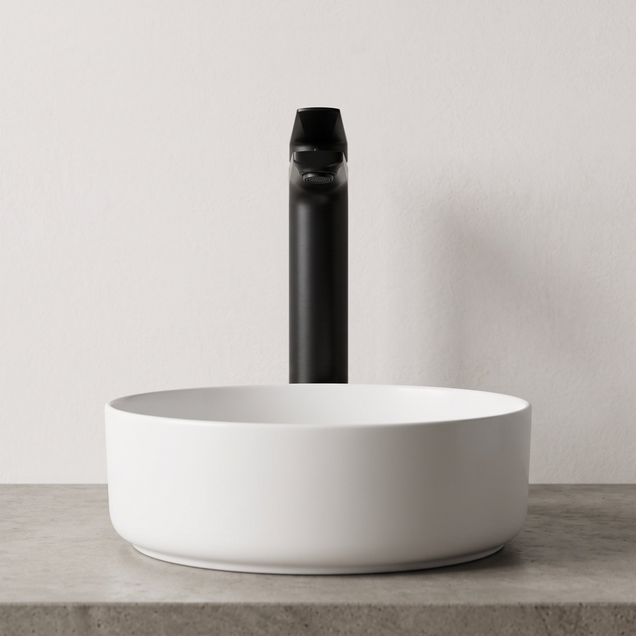 Robinet lavabo Metra Noir Mat modèle haut vu de face derrière une vasque à poser