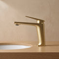 Robinet lavabo Metra Or Brossé modèle court vu de profil sur une vasque encastrée