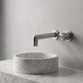 Robinet mural encastrable Muro nickel brossé au-dessus d'une vasque en marbre