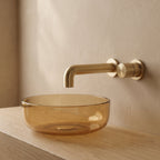 Robinet mural encastrable Muro or brossé au-dessus d'une vasque en verre ambré