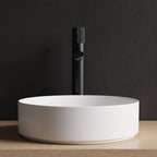 Robinet lavabo Runa noir mat 318 mm derrière une vasque à poser, vue de face