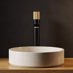 Robinet lavabo Runa noir mat et or brossé 318 mm derrière une vasque à poser, vue de face