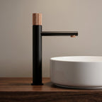 Robinet lavabo Runa noir mat et or rose 318 mm derrière une vasque à poser, vue de profil
