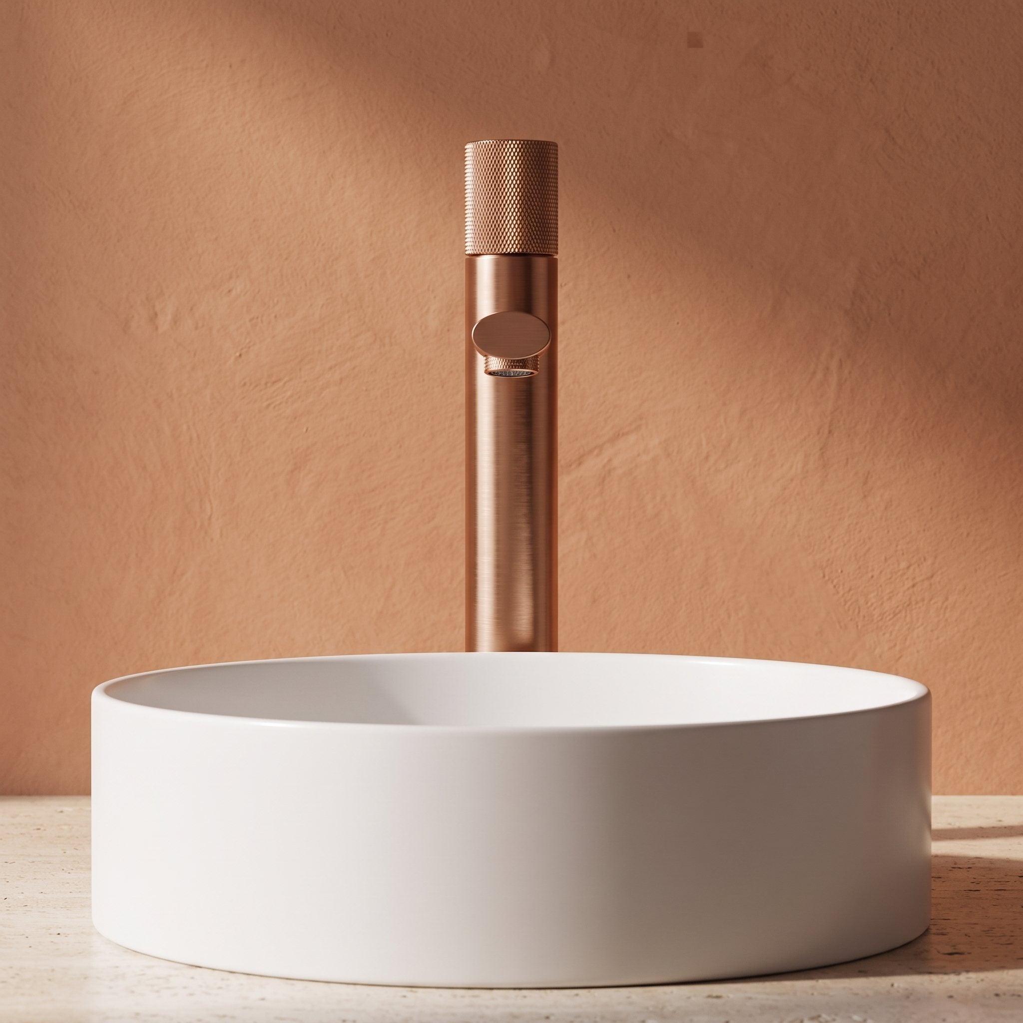 Robinet lavabo Runa or rose brossé 318 mm derrière une vasque à poser, vue de face