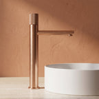Robinet lavabo Runa or rose brossé 318 mm derrière une vasque à poser, vue de profil