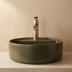Robinet lavabo cascade Vetra bronze antique sur une vasque verte